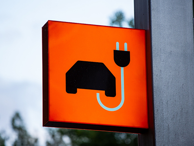 Oranges Schild mit Auto und Ladekabel