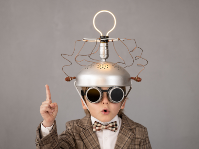 Person mit selbstgebautem Helm und Glühbirne als Symbol für Energieideen.